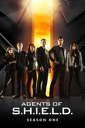 The team standing in a shaft of golden light inside a dark aircraft hangar.