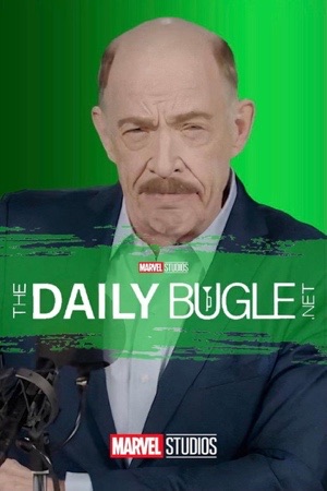 A furious man with a moustache in a blue jacket against a green screen, leaning into a microphone.