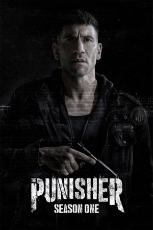 Jon Bernthal in black holding a rifle, half-lit against a black background.
